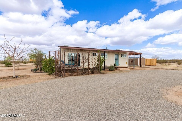 view of front of house with gravel driveway and a carport