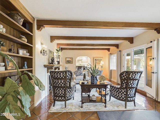 living room featuring beamed ceiling and dark tile patterned floors