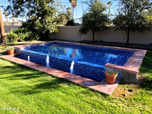 view of swimming pool with a lawn