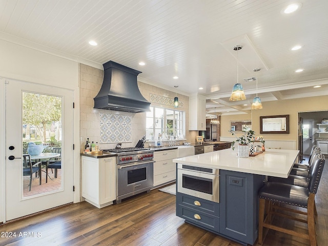 kitchen featuring pendant lighting, custom range hood, dark hardwood / wood-style floors, white cabinetry, and appliances with stainless steel finishes