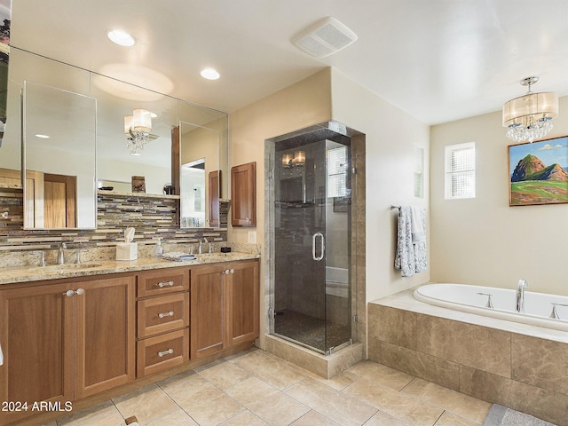 bathroom with tasteful backsplash, an inviting chandelier, vanity, shower with separate bathtub, and tile patterned floors