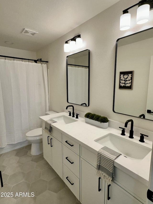 bathroom featuring tile patterned flooring, vanity, walk in shower, and toilet