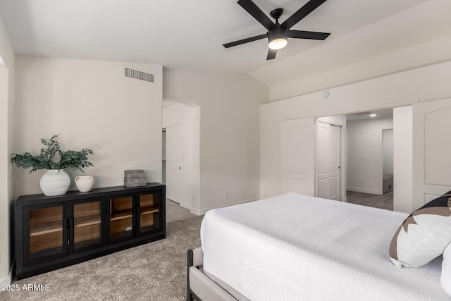 carpeted bedroom featuring ceiling fan, lofted ceiling, and a closet