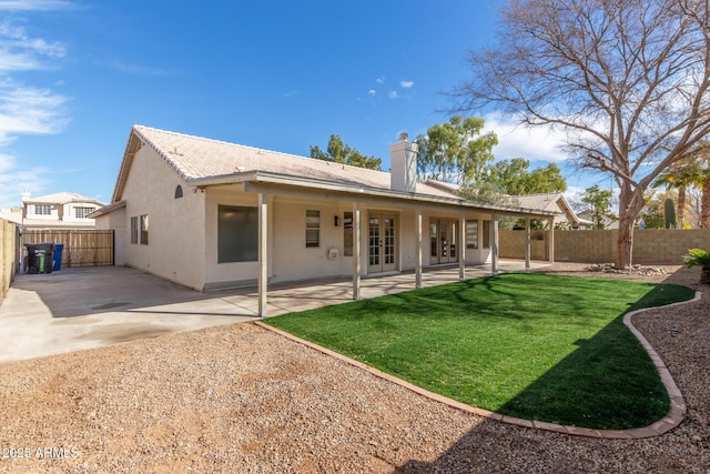 rear view of property with a yard and a patio