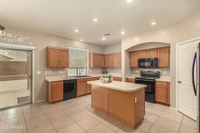 9207 W Kirby Ave, Tolleson, AZ 85353 - kitchen with black appliances, a sink, light countertops, a center island, and light tile patterned flooring