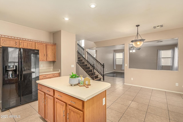9207 W Kirby Ave, Tolleson, AZ 85353 - kitchen featuring black fridge, light tile patterned flooring, light countertops, a ceiling fan, and plenty of natural light