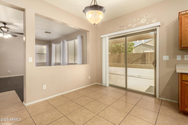 9207 W Kirby Ave, Tolleson, AZ 85353 - unfurnished dining area featuring a ceiling fan, baseboards, and light tile patterned flooring