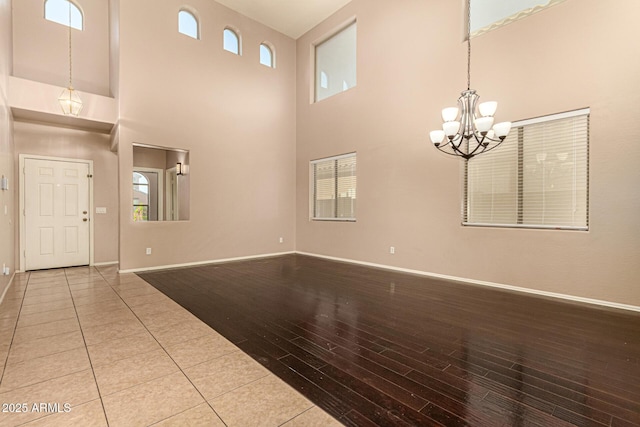 9207 W Kirby Ave, Tolleson, AZ 85353 - foyer entrance featuring wood finished floors, a chandelier, baseboards, a towering ceiling, and plenty of natural light