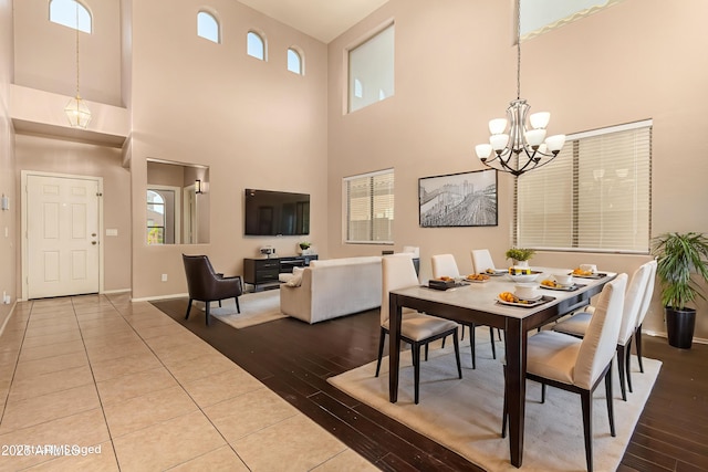 9207 W Kirby Ave, Tolleson, AZ 85353 - dining area featuring a chandelier, wood finished floors, a towering ceiling, and plenty of natural light