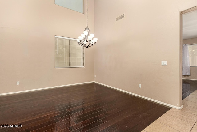 9207 W Kirby Ave, Tolleson, AZ 85353 - spare room with a chandelier, wood finished floors, and baseboards