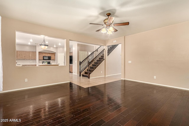 9207 W Kirby Ave, Tolleson, AZ 85353 - unfurnished living room featuring a ceiling fan, light wood-style floors, stairway, and baseboards