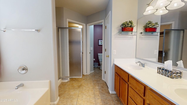 884 W 15th Ave, Apache Junction, AZ 85120 - bathroom featuring double vanity, a garden tub, a shower stall, tile patterned floors, and toilet