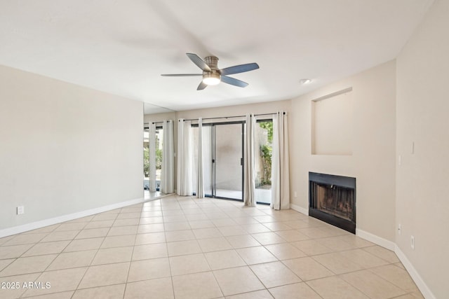 5998 N 78th St Unit 116, Scottsdale, AZ 85250 - unfurnished living room featuring a fireplace, baseboards, a ceiling fan, and plenty of natural light