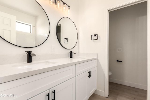8928 E Crescent Ave, Mesa, AZ 85208 - full bath with double vanity, toilet, wood finished floors, and baseboards