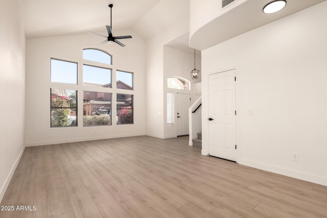 8928 E Crescent Ave, Mesa, AZ 85208 - unfurnished living room featuring high vaulted ceiling, a ceiling fan, light wood-type flooring, baseboards, and stairway