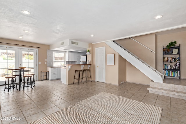 tiled living room with sink and french doors