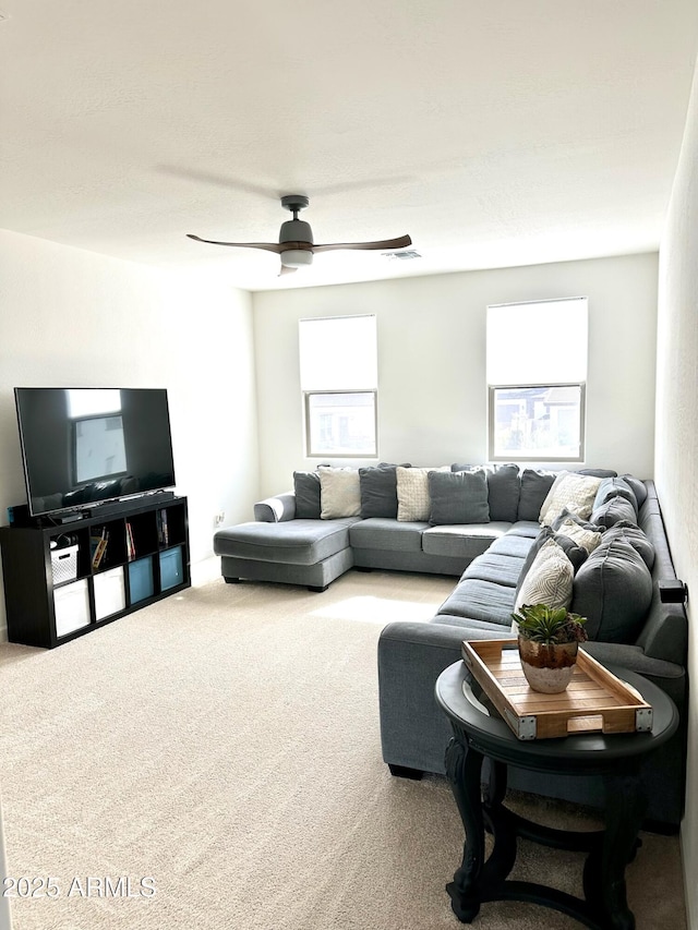 carpeted living room featuring ceiling fan and a healthy amount of sunlight