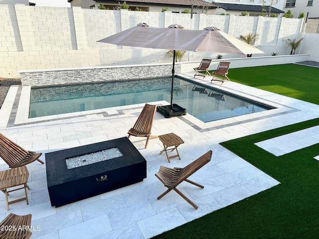 view of swimming pool featuring a patio area, a yard, and a fire pit