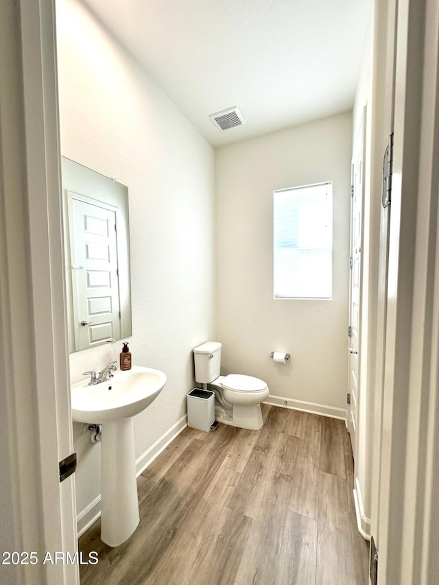 bathroom featuring hardwood / wood-style flooring, toilet, and sink