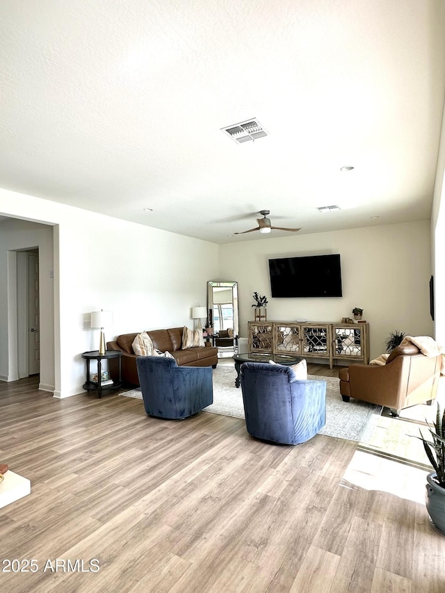 living room with ceiling fan and light hardwood / wood-style flooring