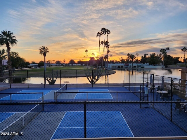 view of tennis court featuring a water view