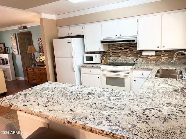 kitchen with dark hardwood / wood-style floors, sink, kitchen peninsula, white appliances, and light stone countertops