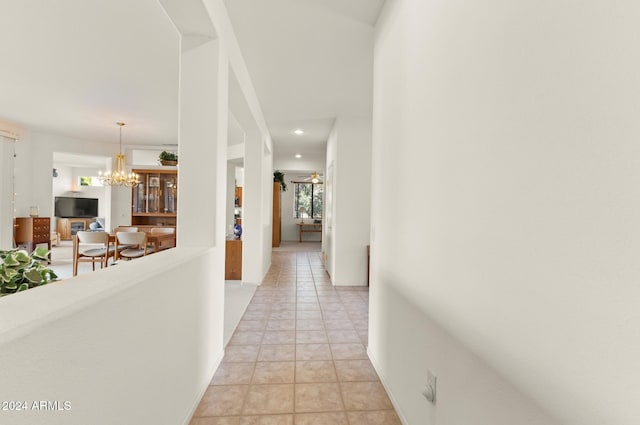 hallway featuring a chandelier and light tile patterned flooring