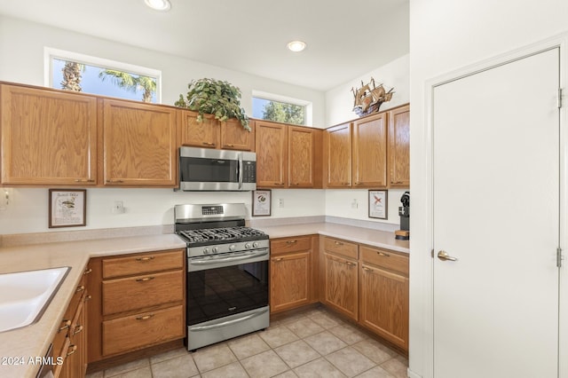 kitchen featuring a wealth of natural light, light tile patterned floors, and appliances with stainless steel finishes