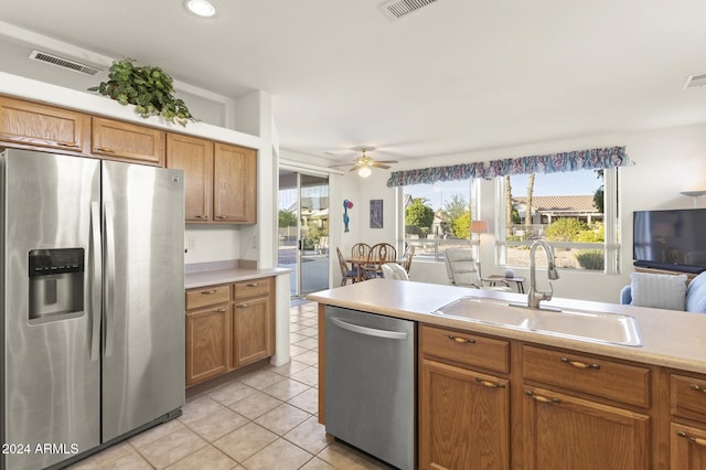 kitchen featuring ceiling fan, sink, light tile patterned flooring, and stainless steel appliances