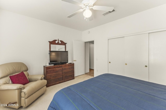 bedroom featuring ceiling fan, light colored carpet, and a closet