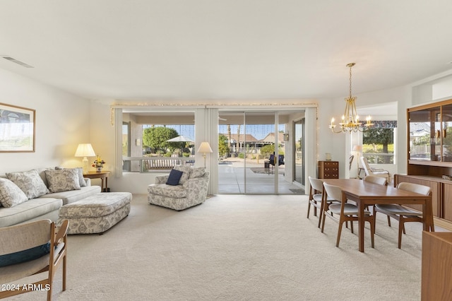 living room featuring a wealth of natural light, carpet, and an inviting chandelier