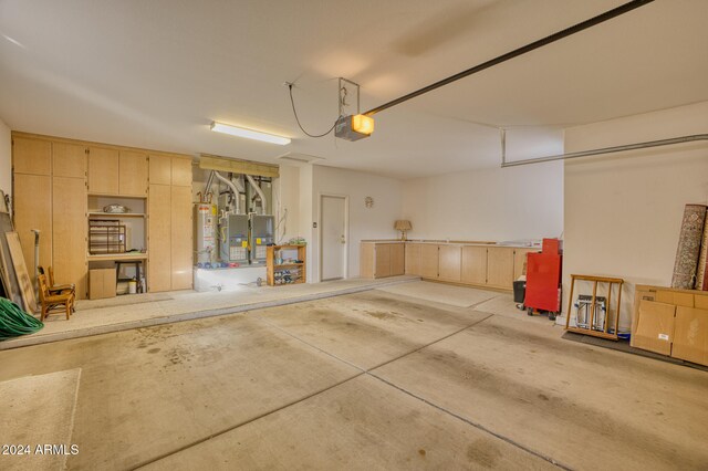 garage with heating unit, a garage door opener, and water heater