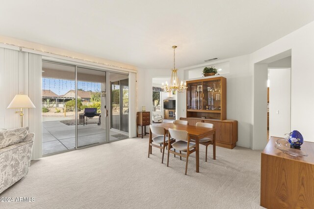 carpeted dining space featuring an inviting chandelier