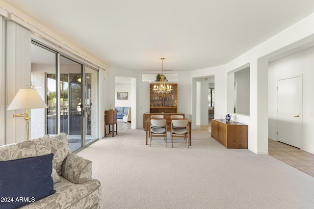 dining space featuring light colored carpet and an inviting chandelier