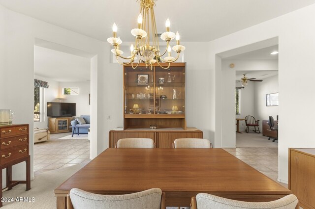 carpeted dining space featuring a wealth of natural light and ceiling fan with notable chandelier