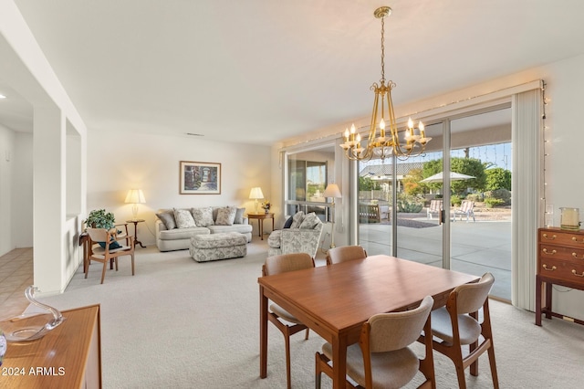 dining room featuring light colored carpet and a chandelier