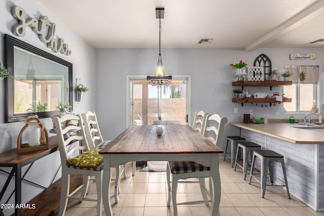 dining area with beamed ceiling and light tile patterned flooring