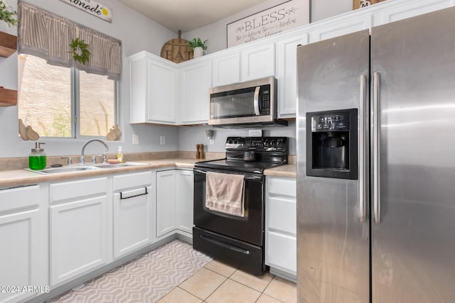 kitchen featuring white cabinetry, sink, light tile patterned flooring, and appliances with stainless steel finishes