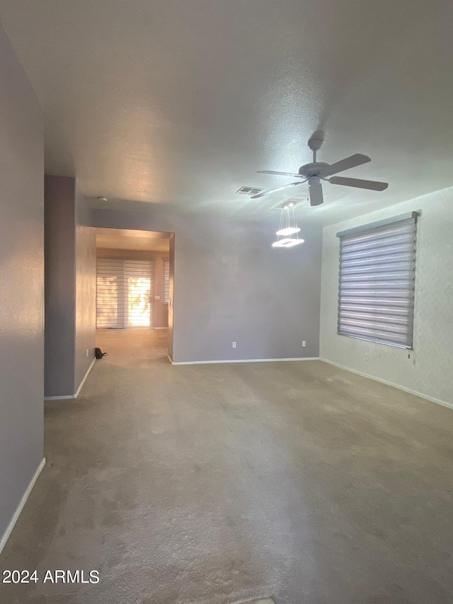 carpeted spare room with ceiling fan