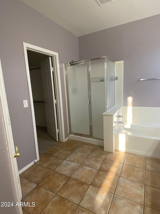 bathroom featuring tile patterned floors and separate shower and tub