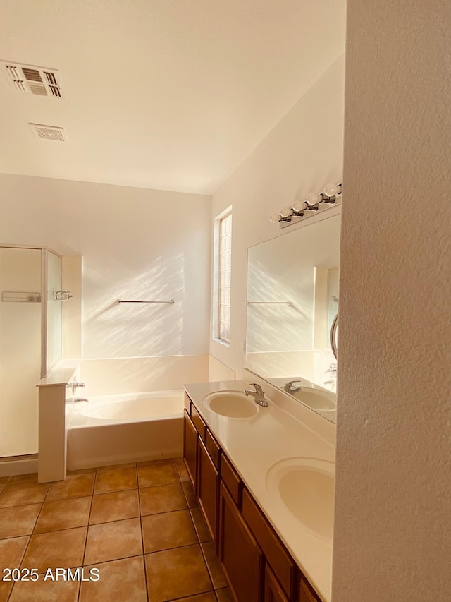 bathroom featuring tile patterned flooring, vanity, and a tub