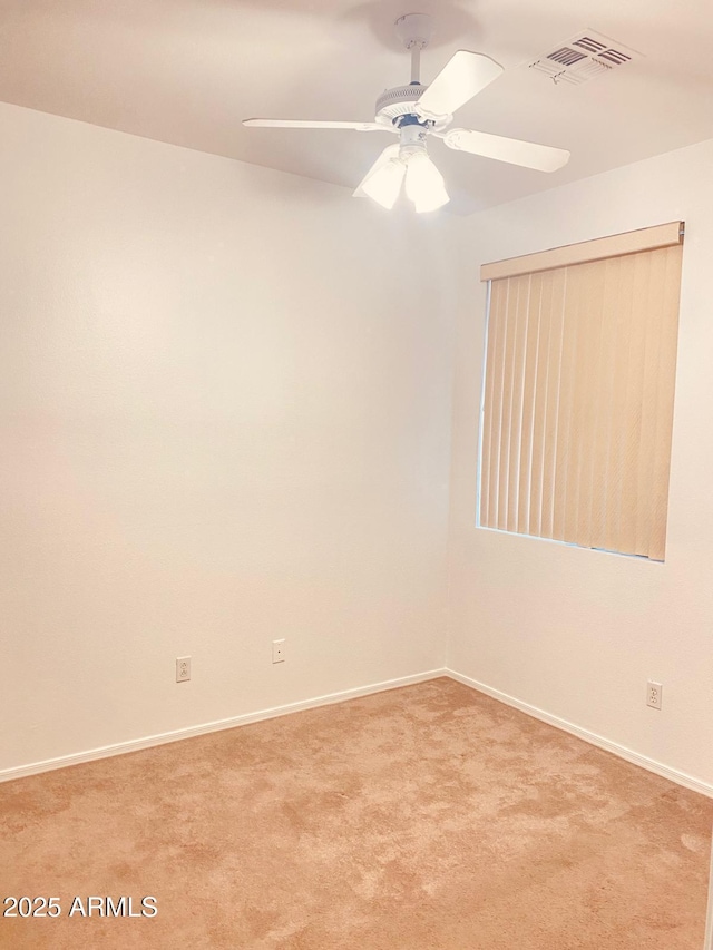 empty room featuring ceiling fan and light carpet