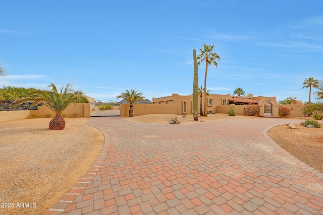 10239 N 125th St, Scottsdale, AZ 85259 - pueblo-style house featuring a gate, curved driveway, stucco siding, and fence