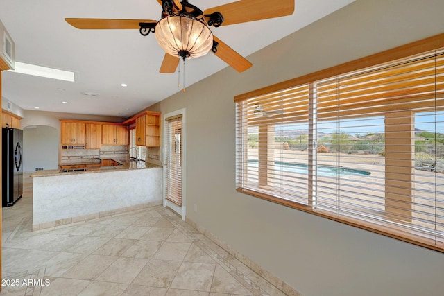 10239 N 125th St, Scottsdale, AZ 85259 - kitchen featuring freestanding refrigerator, a ceiling fan, open shelves, decorative backsplash, and arched walkways