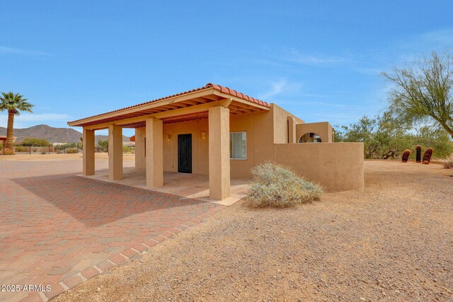 10239 N 125th St, Scottsdale, AZ 85259 - view of property exterior with stucco siding, a mountain view, a tiled roof, and a patio