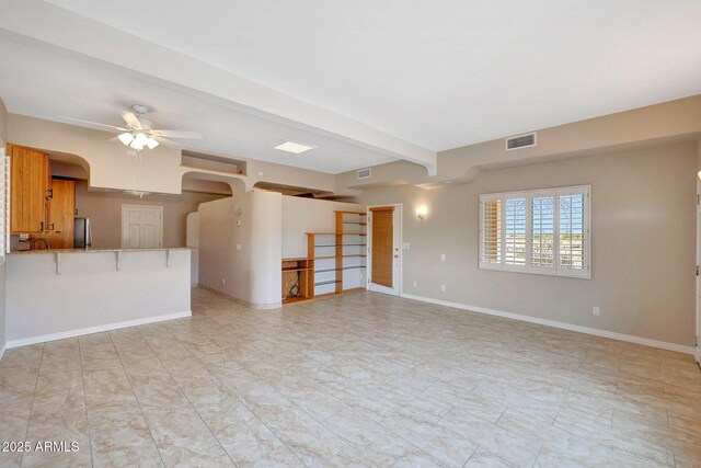 10239 N 125th St, Scottsdale, AZ 85259 - unfurnished living room featuring a ceiling fan, baseboards, arched walkways, and beamed ceiling