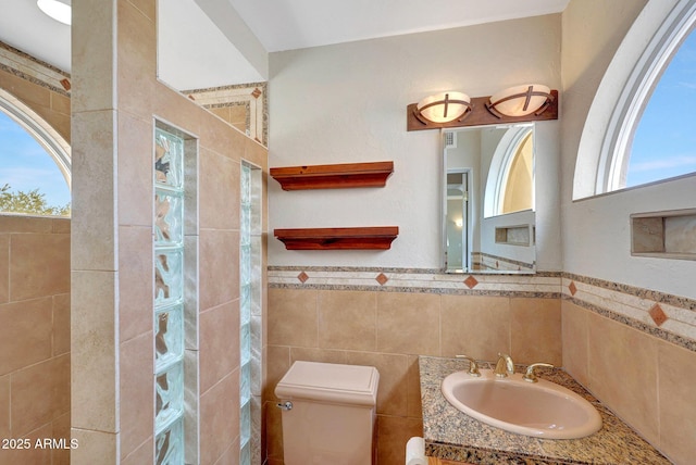 10239 N 125th St, Scottsdale, AZ 85259 - full bathroom featuring a tile shower, tile walls, toilet, vanity, and a wainscoted wall