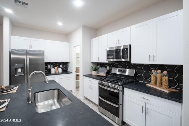 13259 N 145th Ln, Surprise, AZ 85379 - kitchen with visible vents, a sink, appliances with stainless steel finishes, dark countertops, and white cabinetry