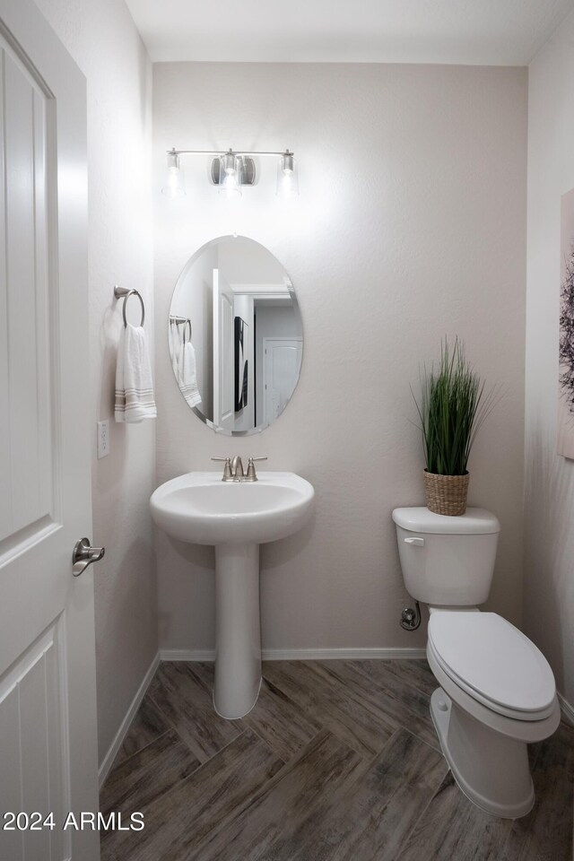 13259 N 145th Ln, Surprise, AZ 85379 - half bathroom with baseboards, a sink, toilet, and wood finished floors