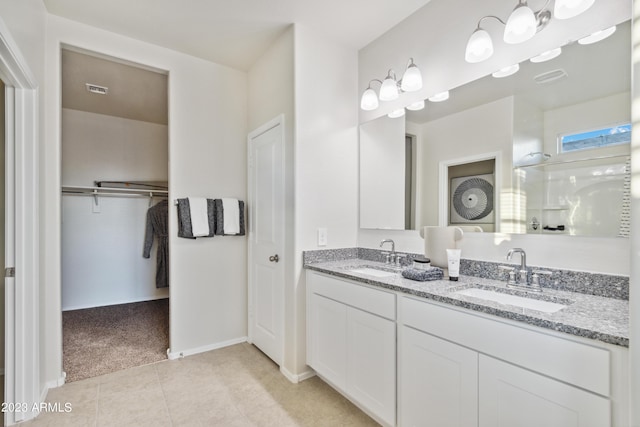 bathroom featuring a shower with door, vanity, and tile patterned flooring